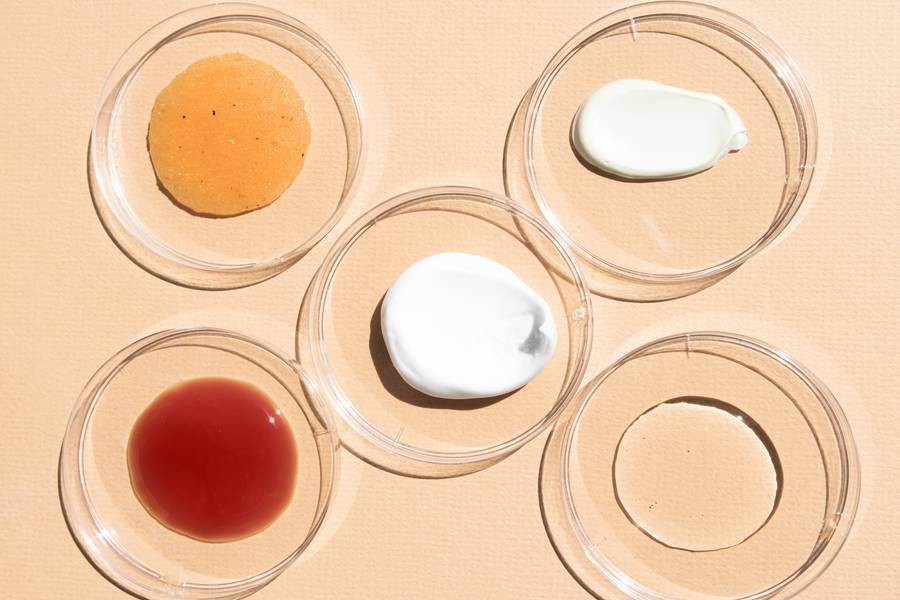 Productos de skincare alineados sobre superficie blanca