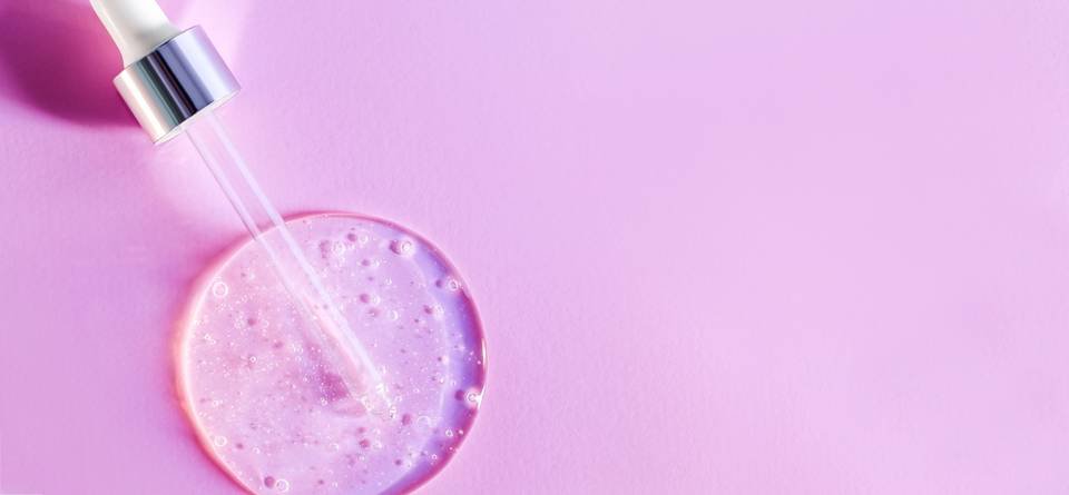 Frascos de sérum y activos cosméticos sobre mesa blanca